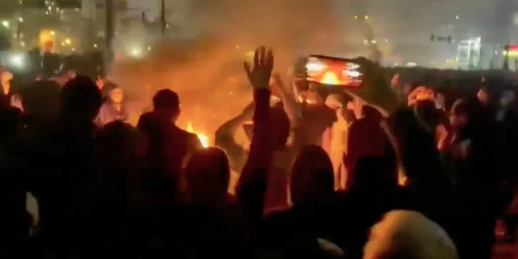 Esta captura de pantalla de un video que circula en redes sociales muestra a manifestantes bailando y vitoreando alrededor de una hoguera en la calle en Teherán, Irán, el 9 de enero de 2026. (UGC vía AP)