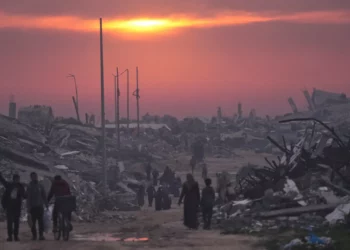 Palestinos caminan entre las ruinas de edificios destruidos mientras el sol se pone sobre la ciudad de Gaza, el 4 de enero de 2026. (Foto AP/Jehad Alshrafi)