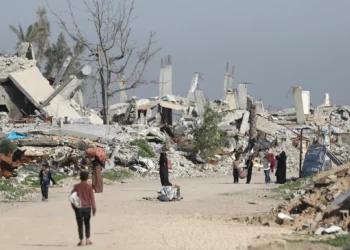 Mujeres y niños recogen leña de casas destruidas en la zona de Mughraqa, 5 de enero de 2026 (Ali Hassan/Flash90)