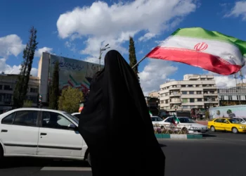 Una mujer ondea una bandera iraní durante una manifestación en apoyo al Gobierno en la plaza Enqelab-e-Eslami, o de la Revolución Islámica, en el centro de Teherán, el 30 de marzo de 2026. (Foto AP/Vahid Salemi)