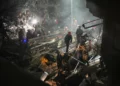 Las fuerzas de seguridad y los equipos de rescate israelíes trabajan entre los escombros de un edificio residencial alcanzado por un misil iraní en Haifa, el 5 de abril de 2026. (Foto AP/Ariel Schalit)