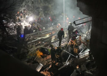 Las fuerzas de seguridad y los equipos de rescate israelíes trabajan entre los escombros de un edificio residencial alcanzado por un misil iraní en Haifa, el 5 de abril de 2026. (Foto AP/Ariel Schalit)