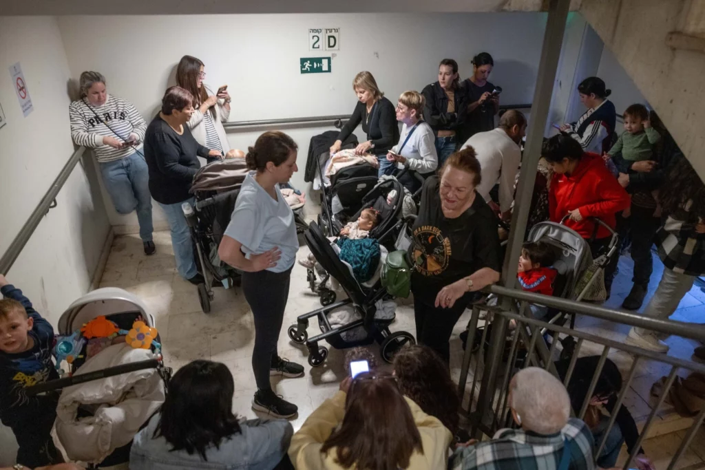 Los israelíes se refugian en un refugio antiaéreo público mientras una sirena avisa de la llegada de misiles lanzados desde Irán, 31 de marzo de 2026. (Miriam Alster/Flash90)