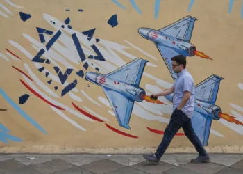 Un hombre pasa junto a un mural antiisraelí en el centro de Teherán, Irán, el 17 de mayo de 2026. (AP/Vahid Salemi)