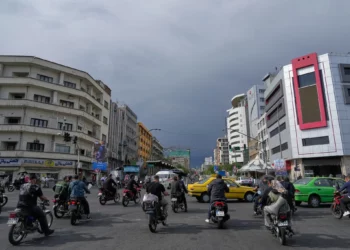 Motocicletas y automóviles cruzan una intersección en el centro de Teherán, Irán, el 17 de mayo de 2026. (AP/Vahid Salemi)