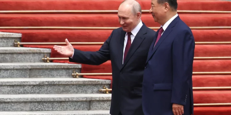 El presidente ruso Vladimir Putin, a la izquierda, camina junto al presidente chino Xi Jinping durante una ceremonia de bienvenida en el Gran Salón del Pueblo en Pekín, el 20 de mayo de 2026. (Maxim Shemetov/Pool Photo vía AP)