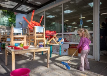 Niños, padres y personal israelíes limpian en “Gan Nitzan” en Givatayim, ya que las escuelas y jardines de infancia están a punto de reabrir después de haber permanecido cerrados durante más de un mes debido a la guerra con Irán, 8 de abril de 2026. (Miriam Alster/Flash90)