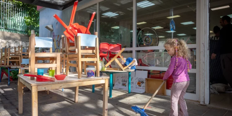 Niños, padres y personal israelíes limpian en “Gan Nitzan” en Givatayim, ya que las escuelas y jardines de infancia están a punto de reabrir después de haber permanecido cerrados durante más de un mes debido a la guerra con Irán, 8 de abril de 2026. (Miriam Alster/Flash90)