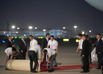 Trabajadores extienden una alfombra roja a la llegada del presidente estadounidense Donald Trump a bordo del Air Force One, el 13 de mayo de 2026, al Aeropuerto Internacional de la Capital de Pekín (Foto AP/Mark Schiefelbein).