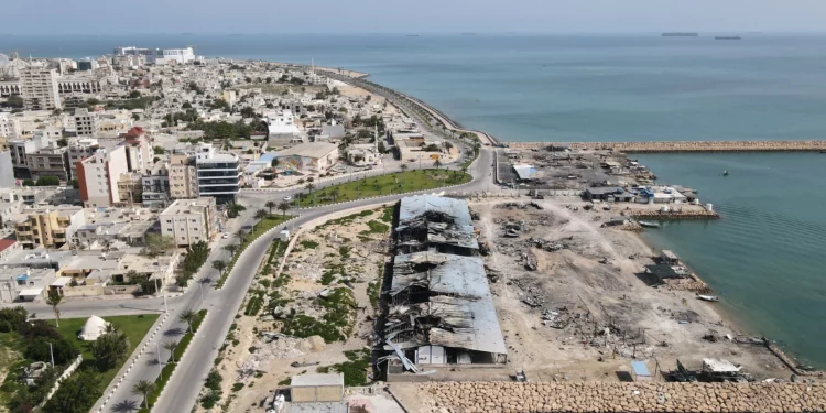 Con barcos en el estrecho de Ormuz como telón de fondo, se aprecian los daños, según testigos locales, causados por varios ataques aéreos, en un muelle pesquero del puerto de la isla de Qeshm, Irán, el 13 de abril de 2026. (Asghar Besharati/AP)
