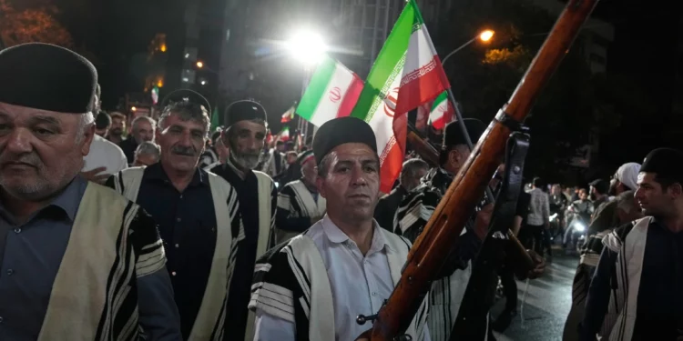 Nómadas bakhtiari, vestidos con trajes tradicionales, corean consignas durante una concentración a favor del gobierno cerca de la residencia donde fue asesinado el exlíder supremo iraní, el ayatolá Alí Jamenei, en Teherán, Irán, el 18 de mayo de 2026. (AP/Vahid Salemi)
