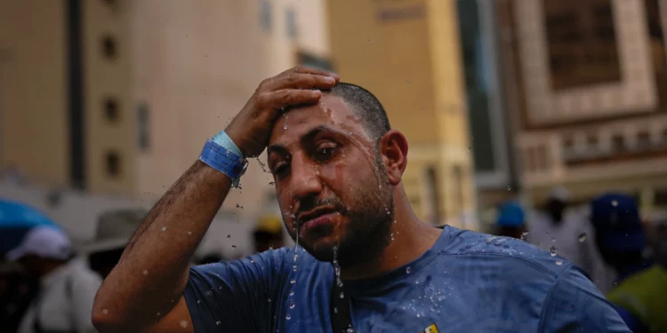 Un peregrino musulmán se refresca la cabeza con agua a las afueras de la Gran Mezquita durante la peregrinación anual del Hajj en la ciudad santa de La Meca, Arabia Saudita, el 24 de mayo de 2026. (Foto AP/Altaf Qadri)