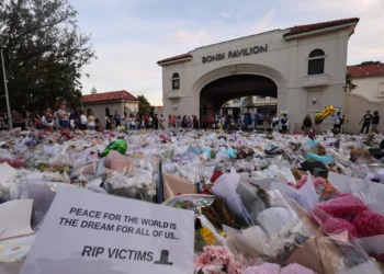 En la fotografía se ve una nota junto a las ofrendas florales depositadas en Bondi Pavilion en memoria de las víctimas de la masacre terrorista perpetrada días antes contra un evento de Jánuca en Bondi Beach, Sídney, Australia, el 20 de diciembre de 2025. (DAVID GRAY / AFP)