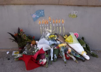 Ofrendas florales en memoria de las víctimas se depositan en un pequeño puente donde unos hombres armados se apostaron durante un tiroteo terrorista masivo perpetrado contra un evento de Jánuca casi una semana antes, en Bondi Beach, Sídney, Australia, el 20 de diciembre de 2025. (Foto de DAVID GRAY / AFP)