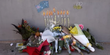 Ofrendas florales en memoria de las víctimas se depositan en un pequeño puente donde unos hombres armados se apostaron durante un tiroteo terrorista masivo perpetrado contra un evento de Jánuca casi una semana antes, en Bondi Beach, Sídney, Australia, el 20 de diciembre de 2025. (Foto de DAVID GRAY / AFP)