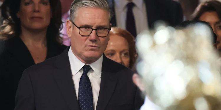 El primer ministro británico, Keir Starmer, en el centro, camina por la Cámara de los Comunes para asistir a la Apertura del Parlamento en el Palacio de Westminster, Londres, el 13 de mayo de 2026. (Toby Melville/Pool vía AP)