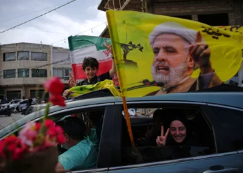 Residentes desplazados ondean una bandera con la imagen del líder de Hezbolá, Naim Qassem, al regresar a sus aldeas tras un alto el fuego entre Israel y Hezbolá, en Zefta, al sur del Líbano, el 17 de abril de 2026. (Foto AP/Hassan Ammar)