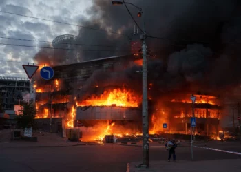 Un hombre saca una caja de un centro comercial en llamas tras un ataque ruso en Kiev, Ucrania, el 24 de mayo de 2026. (Foto AP/Evgeniy Maloletka)