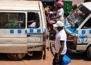 Un hombre con mascarilla protectora camina por una calle concurrida de Kampala, Uganda, el 19 de mayo de 2026. (Foto AP/Hajarah Nalwadda)