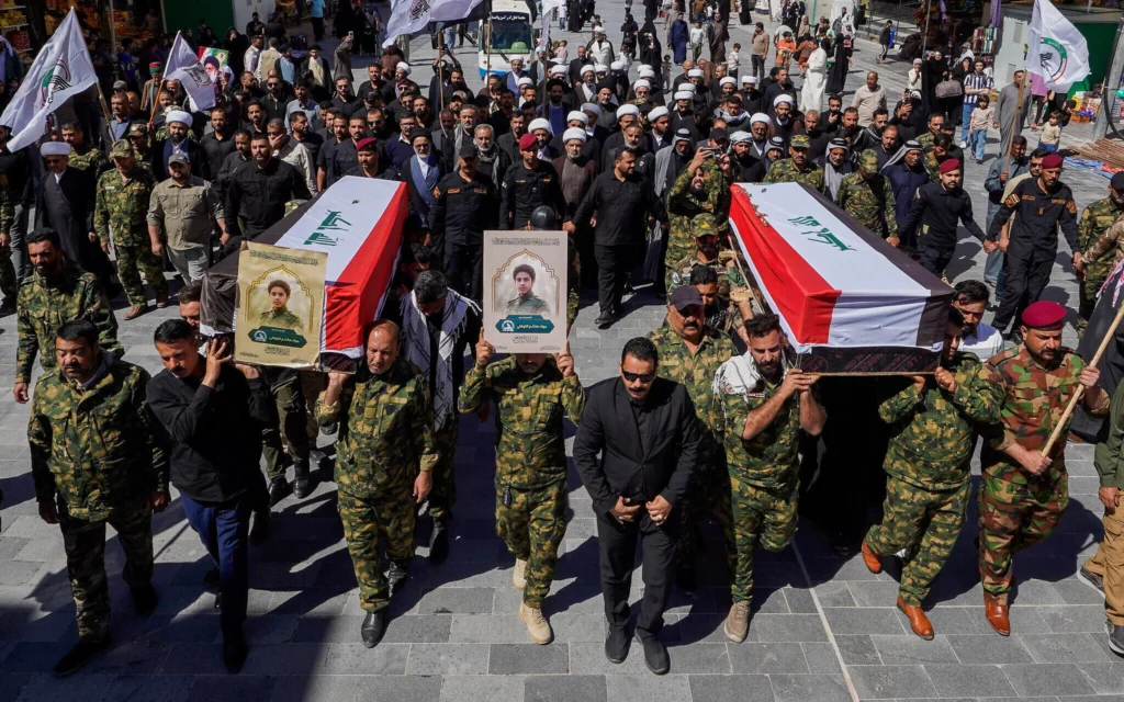 Miembros de las Fuerzas de Movilización Popular del ejército iraquí, integradas por milicias chiitas proiraníes, asisten en Nayaf (Irak) al funeral de sus compañeros fallecidos en un ataque aéreo estadounidense en Anbar, el 1 de abril de 2026. (Foto AP/Anmar Khalil)
