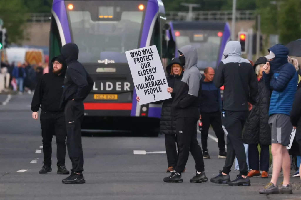 Una multitud de manifestantes se reúne en la carretera tras un incidente de apuñalamiento en el norte de Belfast, el 9 de junio de 2026. (Peter Morrison/AP)