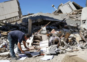 Un hombre inspecciona los daños en el lugar donde se encontraba el edificio del banco central del Líbano, que fue blanco de un ataque israelí el día anterior, en la ciudad libanesa de Nabatieh, al sur del país, el 21 de junio de 2026. (Abbas FAKIH / AFP)