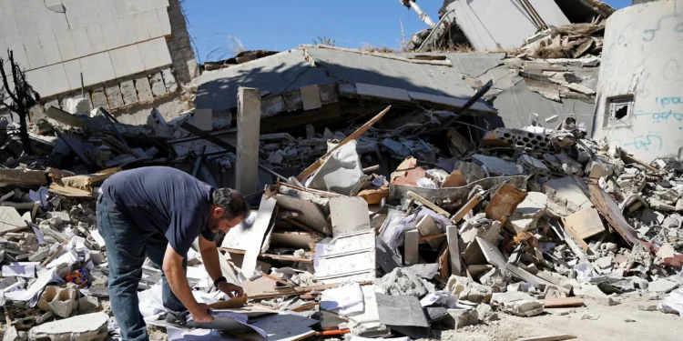 Un hombre inspecciona los daños en el lugar donde se encontraba el edificio del banco central del Líbano, que fue blanco de un ataque israelí el día anterior, en la ciudad libanesa de Nabatieh, al sur del país, el 21 de junio de 2026. (Abbas FAKIH / AFP)
