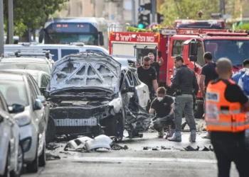 La policía y los servicios de rescate en el lugar donde explotó un coche en lo que parece ser un asesinato relacionado con las bandas, en Jaffa, el 28 de junio de 2026. (Avshalom Sassoni/Flash90)