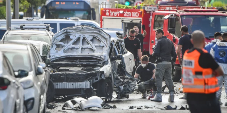 La policía y los servicios de rescate en el lugar donde explotó un coche en lo que parece ser un asesinato relacionado con las bandas, en Jaffa, el 28 de junio de 2026. (Avshalom Sassoni/Flash90)