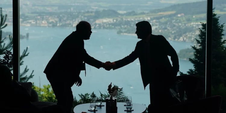 Los miembros del personal de las delegaciones se reúnen en el vestíbulo el primer día de una reunión cuatripartita entre Estados Unidos, Irán, Pakistán y Catar en el Buergenstock Resort Lake Lucerne, cerca de Stansstad, Suiza, el 21 de junio de 2026. (Nathan Howard/Foto de pool vía AP)