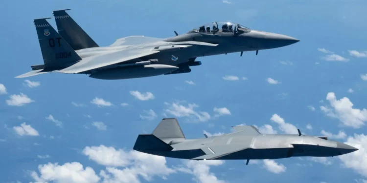 Un F-15EX Eagle II vuela junto a un MQ-28 Ghost Bat