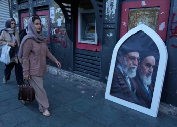 Los peatones pasan junto a un cartel en el que aparecen el líder supremo iraní asesinado, el ayatolá Ali Jamenei (a la izquierda), y el difunto fundador de la revolución, el ayatolá Jomeini, en una acera de la plaza de la Revolución Islámica de Teherán (Irán), el domingo 14 de junio de 2026. (AP/Vahid Salemi)