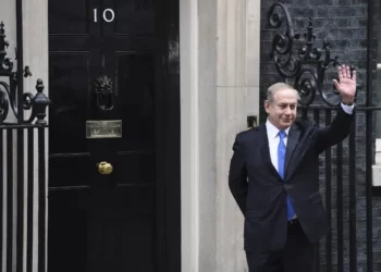 El primer ministro Benjamin Netanyahu saluda a los medios de comunicación tras su llegada al número 10 de Downing Street en Londres para una reunión con su homóloga británica, Theresa May, el 6 de febrero de 2017. (Foto AFP/Chris J Ratcliffe)