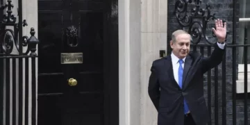 El primer ministro Benjamin Netanyahu saluda a los medios de comunicación tras su llegada al número 10 de Downing Street en Londres para una reunión con su homóloga británica, Theresa May, el 6 de febrero de 2017. (Foto AFP/Chris J Ratcliffe)