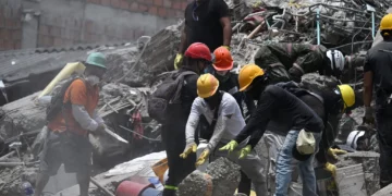 Equipos de rescate y voluntarios buscan supervivientes entre los escombros de un edificio derrumbado tras el terremoto que sacudió Cali, Colombia, el 12 de agosto de 2026. (Raul ARBOLEDA/AFP)