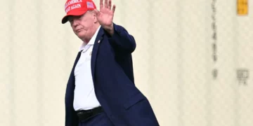 El presidente estadounidense Donald Trump saluda mientras camina hacia su caravana tras bajar del helicóptero Marine One en la Elipse, cerca de la Casa Blanca, el 16 de agosto de 2026. (Mandel NGAN/AFP)