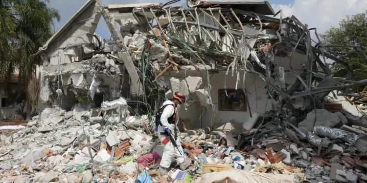 Un soldado israelí pasa junto a una casa destruida por terroristas de Hamás en el kibutz Be'eri, el 11 de octubre de 2023. (AP/Baz Ratner)