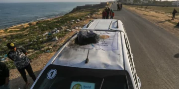 Palestinos inspeccionan un vehículo con el logotipo de la Cocina Central Mundial destruido por un ataque aéreo israelí en Deir al Balah, Franja de Gaza, el 2 de abril de 2024. (Ismael Abu Dayyah/AP)