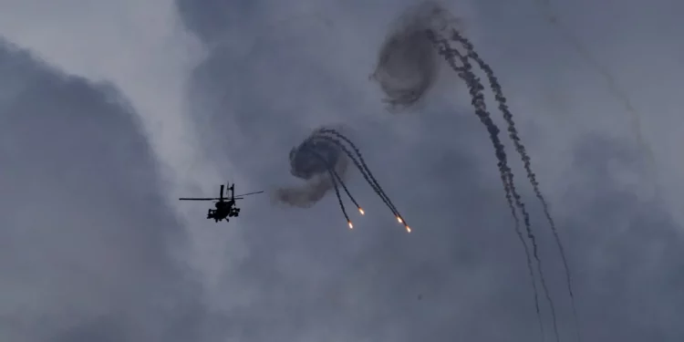 Un helicóptero Apache israelí lanza bengalas cerca de la frontera entre Israel y Líbano, visto desde el norte de Israel, el 2 de octubre de 2024. (AP/Baz Ratner)