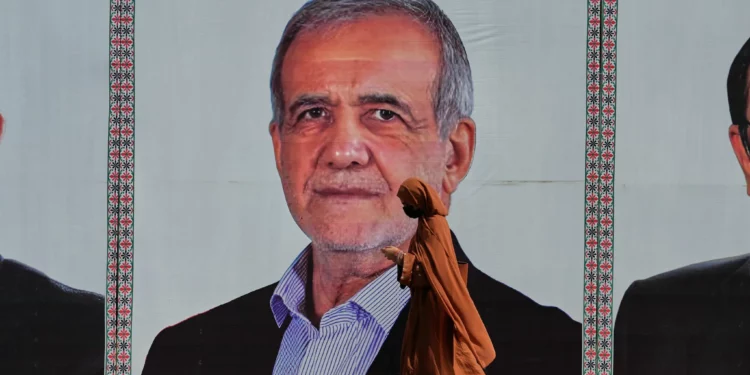 Una mujer pasa junto a una valla publicitaria de bienvenida con la imagen del presidente iraní Masoud Pezeshkian en una carretera de Islamabad, Pakistán, el martes 23 de junio de 2026. (Foto AP/Anjum Naveed)