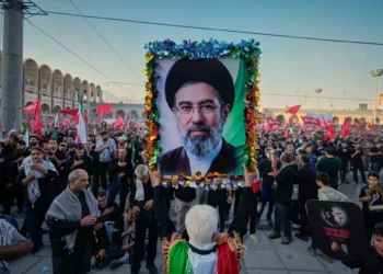 Un hombre sostiene una fotografía del nuevo líder supremo de Irán, Mojtaba Jamenei, en la Gran Mezquita Imam Khomeini Mosalla, durante las ceremonias fúnebres del asesinado líder supremo, el ayatolá Alí Jamenei, y miembros de su familia en Teherán, Irán, el 5 de julio de 2026. (AP/Altaf Qadri)
