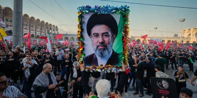 Un hombre sostiene una fotografía del nuevo líder supremo de Irán, Mojtaba Jamenei, en la Gran Mezquita Imam Khomeini Mosalla, durante las ceremonias fúnebres del asesinado líder supremo, el ayatolá Alí Jamenei, y miembros de su familia en Teherán, Irán, el 5 de julio de 2026. (AP/Altaf Qadri)