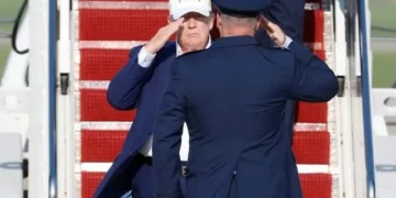 El presidente de Estados Unidos, Donald Trump (izquierda), es recibido por el coronel de la Fuerza Aérea Christopher M. Robinson, comandante del 89.º Ala de Transporte Aéreo, tras bajar las escaleras del Air Force One a su llegada a la Base Conjunta Andrews, Maryland, el 9 de agosto de 2026. (Foto AP/Luis M. Alvarez)
