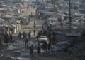 Palestinos caminan entre tiendas de campaña y escombros de edificios destruidos durante la guerra entre Israel y Hamás a lo largo de la carretera costera en la ciudad de Gaza, el 13 de agosto de 2026. (Foto AP/Abdel Kareem Hana)