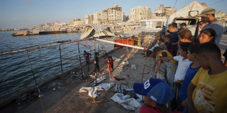Palestinos inspeccionan los daños tras un ataque aéreo israelí contra una cafetería en el puerto de Gaza, en la ciudad de Gaza, el 18 de agosto de 2026. (Foto AP/Jehad Alshrafi)
