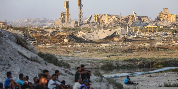 Palestinos cerca de edificios destruidos durante la reciente guerra entre Israel y Hamás, en la ciudad de Gaza, en el centro de la Franja de Gaza, el 31 de julio de 2026. (Ali Hassan/Flash90)