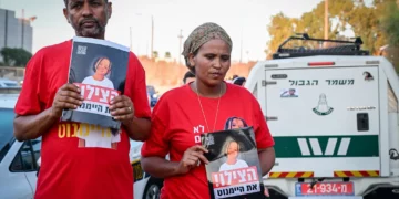 Los padres de la niña desaparecida Haymanut Kasau fueron vistos protestando y sosteniendo su fotografía en Tel Aviv el 12 de agosto de 2026. (Avshalom Sassoni/Flash90)