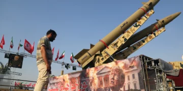 Un hombre observa una pancarta que representa al presidente estadounidense Donald Trump exhibida frente a los misiles balísticos Zolfaghar y Zolghadr exhibidos en la Plaza Azadi de Teherán, la capital de Irán, el 2 de agosto de 2026. (Fatemeh Bahrami / Anadolu vía Reuters)