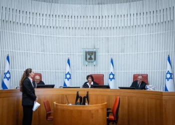 El Tribunal Superior rechaza el recurso de Sharren Haskel contra el Likud El Tribunal Superior de Justicia rechazó este domingo por la noche el recurso de la diputada Sharren Haskel contra el Likud y la facción Derecha Estatal. Haskel pretendía ser reconocida como una facción unipersonal y obtener autorización para abandonar su grupo parlamentario antes de las elecciones a la 26.ª Knéset. Aunque los jueces desestimaron su petición, la sentencia advirtió que la fórmula escogida por ambas formaciones para aplicar sus acuerdos podría generar un problema jurídico al afectar el derecho de los diputados contrarios a una fusión a separarse de su facción. El origen del litigio se encuentra en el acuerdo suscrito en marzo de 2025 entre el Likud y Derecha Estatal, entonces denominada Nueva Esperanza. El pacto contemplaba originalmente la fusión Estatal con el Likud, siempre que recibiera la aprobación del Comité de la Knéset. También incluía otros compromisos políticos, como la incorporación de miembros Estatal al Likud, la posibilidad de reservar un puesto para un candidato en la lista del partido y la participación conjunta en las elecciones a la 26.ª Knéset. Ese esquema cambió el 14 de julio de 2026. En vez de culminar formalmente la fusión, las dos facciones decidieron presentarse a las próximas elecciones mediante una lista conjunta de candidatos. El resto de las disposiciones pactadas continuaría en vigor con las modificaciones necesarias. Esta decisión se convirtió en el elemento central de la demanda de Haskel. La diputada argumentó que, pese a la ausencia de una fusión formal, en la práctica ambas formaciones ya funcionaban como si la integración se hubiera producido. Señaló que llevaban un periodo prolongado de estrecha coordinación, que habían combinado actividades políticas y que ya preparaban conjuntamente la campaña electoral. Según su posición, evitar la culminación oficial de la fusión le impedía utilizar el derecho legal a separarse de una facción que se integra en otra. Su argumento se apoyaba en el artículo 59 de la Ley de la Knéset, que permite, bajo determinadas condiciones, que un diputado contrario a la fusión de su grupo parlamentario se separe de él. Esa modalidad de salida tiene efectos distintos de una separación ordinaria tanto sobre el estatus parlamentario como sobre la financiación partidaria. El tribunal explicó que un diputado que abandona una facción al amparo de ese artículo puede ser reconocido como facción unipersonal y presentarse a las siguientes elecciones integrado en otro partido. Sin embargo, los jueces concluyeron que Haskel había actuado con un retraso considerable. El acuerdo entre el Likud y Derecha Estatal databa de marzo de 2025, pero ella no acudió al Comité de la Knéset hasta el 14 de julio de 2026, pocos días antes de la “fecha determinante” empleada para calcular los anticipos de financiación electoral. La sentencia recordó que las elecciones a la 26.ª Knéset debían celebrarse, como fecha límite, el 27 de octubre. Por ese motivo, la fecha determinante era el 18 de julio, trasladada al 19 de julio debido a que el día 18 caía en sábado. El juez Yitzhak Amit, con el respaldo de las juezas Daphne Barak-Erez y Alex Stein, consideró que existía una “demora sustancial” suficiente para rechazar el recurso. El tribunal destacó que Haskel dejó transcurrir más de un año sin hacer valer su argumento de que la fusión se estaba ejecutando de hecho. Tampoco acudió a la justicia cuando, según su propia interpretación, comenzaron a producirse las actuaciones que demostraban que la integración entre ambas formaciones ya estaba en marcha. Para los jueces, esa falta de actuación también debilitaba su afirmación de que se había opuesto de manera continuada a la fusión durante todo ese periodo. Además del problema temporal, el Tribunal Superior tampoco aceptó la posición de Haskel sobre el fondo. Según la sentencia, Derecha Estatal siguió operando en la Knéset como una facción independiente: mantuvo representación propia en los órganos correspondientes, recibió por separado oficinas, presupuestos y personal y ni siquiera celebró una reunión conjunta de facción con el Likud. El Likud sostuvo igualmente que la fusión nunca llegó a completarse y recordó que cualquier cambio en la estructura de las facciones parlamentarias necesita la aprobación del Comité de la Knéset. Pese al rechazo del recurso, Amit introdujo una reserva que podría adquirir relevancia en casos posteriores. El presidente del tribunal cuestionó la fórmula mediante la cual el Likud y Derecha Estatal decidieron concurrir juntos a las elecciones sin completar antes la fusión de sus respectivas facciones parlamentarias. Amit señaló que un acuerdo de ese tipo “podría plantear dificultades”, porque podría impedir que un diputado contrario a la integración ejerciera de manera efectiva un derecho reconocido por la legislación. No obstante, precisó que el caso de Haskel no era el adecuado para resolver esa cuestión. La sentencia dejó abierta la posibilidad de analizarla en otro procedimiento al indicar que “es posible que un acuerdo de este tipo requiera, en la ocasión adecuada, un examen independiente”. Los jueces también hicieron hincapié en la necesidad de contención judicial cuando se examinan acuerdos políticos y cuestiones internas de la Knéset. De acuerdo con la sentencia, la intervención del tribunal frente a un pacto de naturaleza claramente política debe limitarse a situaciones excepcionales, como aquellas en las que exista ilegalidad o una vulneración del orden público. En este caso, no se presentó ningún argumento de ese tipo que justificara la intervención. El recurso se inscribe en el enfrentamiento político que se aumentó después de que Gideon Saar y los integrantes Estatal completaran su acercamiento al Likud. Haskel se negó a incorporarse al Likud, fundó en julio el partido “Israel Primero” y pidió autorización para abandonar Derecha Estatal con el objetivo de concurrir a las elecciones de manera independiente. La diputada no consiguió finalmente lo que reclamaba. El Tribunal Superior rechazó su recurso y tampoco obligó al Likud ni a Derecha Estatal a culminar formalmente la fusión. Al mismo tiempo, la resolución mantuvo abierta una cuestión jurídica sobre el mecanismo elegido por ambos partidos para presentarse juntos a las elecciones, especialmente por sus posibles efectos sobre los derechos de diputados que se nieguen a formar parte de esa iniciativa. Según se desprende de la sentencia, ese asunto podría ser examinado nuevamente por los tribunales en el futuro.