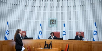 El Tribunal Superior rechaza el recurso de Sharren Haskel contra el Likud El Tribunal Superior de Justicia rechazó este domingo por la noche el recurso de la diputada Sharren Haskel contra el Likud y la facción Derecha Estatal. Haskel pretendía ser reconocida como una facción unipersonal y obtener autorización para abandonar su grupo parlamentario antes de las elecciones a la 26.ª Knéset. Aunque los jueces desestimaron su petición, la sentencia advirtió que la fórmula escogida por ambas formaciones para aplicar sus acuerdos podría generar un problema jurídico al afectar el derecho de los diputados contrarios a una fusión a separarse de su facción. El origen del litigio se encuentra en el acuerdo suscrito en marzo de 2025 entre el Likud y Derecha Estatal, entonces denominada Nueva Esperanza. El pacto contemplaba originalmente la fusión Estatal con el Likud, siempre que recibiera la aprobación del Comité de la Knéset. También incluía otros compromisos políticos, como la incorporación de miembros Estatal al Likud, la posibilidad de reservar un puesto para un candidato en la lista del partido y la participación conjunta en las elecciones a la 26.ª Knéset. Ese esquema cambió el 14 de julio de 2026. En vez de culminar formalmente la fusión, las dos facciones decidieron presentarse a las próximas elecciones mediante una lista conjunta de candidatos. El resto de las disposiciones pactadas continuaría en vigor con las modificaciones necesarias. Esta decisión se convirtió en el elemento central de la demanda de Haskel. La diputada argumentó que, pese a la ausencia de una fusión formal, en la práctica ambas formaciones ya funcionaban como si la integración se hubiera producido. Señaló que llevaban un periodo prolongado de estrecha coordinación, que habían combinado actividades políticas y que ya preparaban conjuntamente la campaña electoral. Según su posición, evitar la culminación oficial de la fusión le impedía utilizar el derecho legal a separarse de una facción que se integra en otra. Su argumento se apoyaba en el artículo 59 de la Ley de la Knéset, que permite, bajo determinadas condiciones, que un diputado contrario a la fusión de su grupo parlamentario se separe de él. Esa modalidad de salida tiene efectos distintos de una separación ordinaria tanto sobre el estatus parlamentario como sobre la financiación partidaria. El tribunal explicó que un diputado que abandona una facción al amparo de ese artículo puede ser reconocido como facción unipersonal y presentarse a las siguientes elecciones integrado en otro partido. Sin embargo, los jueces concluyeron que Haskel había actuado con un retraso considerable. El acuerdo entre el Likud y Derecha Estatal databa de marzo de 2025, pero ella no acudió al Comité de la Knéset hasta el 14 de julio de 2026, pocos días antes de la “fecha determinante” empleada para calcular los anticipos de financiación electoral. La sentencia recordó que las elecciones a la 26.ª Knéset debían celebrarse, como fecha límite, el 27 de octubre. Por ese motivo, la fecha determinante era el 18 de julio, trasladada al 19 de julio debido a que el día 18 caía en sábado. El juez Yitzhak Amit, con el respaldo de las juezas Daphne Barak-Erez y Alex Stein, consideró que existía una “demora sustancial” suficiente para rechazar el recurso. El tribunal destacó que Haskel dejó transcurrir más de un año sin hacer valer su argumento de que la fusión se estaba ejecutando de hecho. Tampoco acudió a la justicia cuando, según su propia interpretación, comenzaron a producirse las actuaciones que demostraban que la integración entre ambas formaciones ya estaba en marcha. Para los jueces, esa falta de actuación también debilitaba su afirmación de que se había opuesto de manera continuada a la fusión durante todo ese periodo. Además del problema temporal, el Tribunal Superior tampoco aceptó la posición de Haskel sobre el fondo. Según la sentencia, Derecha Estatal siguió operando en la Knéset como una facción independiente: mantuvo representación propia en los órganos correspondientes, recibió por separado oficinas, presupuestos y personal y ni siquiera celebró una reunión conjunta de facción con el Likud. El Likud sostuvo igualmente que la fusión nunca llegó a completarse y recordó que cualquier cambio en la estructura de las facciones parlamentarias necesita la aprobación del Comité de la Knéset. Pese al rechazo del recurso, Amit introdujo una reserva que podría adquirir relevancia en casos posteriores. El presidente del tribunal cuestionó la fórmula mediante la cual el Likud y Derecha Estatal decidieron concurrir juntos a las elecciones sin completar antes la fusión de sus respectivas facciones parlamentarias. Amit señaló que un acuerdo de ese tipo “podría plantear dificultades”, porque podría impedir que un diputado contrario a la integración ejerciera de manera efectiva un derecho reconocido por la legislación. No obstante, precisó que el caso de Haskel no era el adecuado para resolver esa cuestión. La sentencia dejó abierta la posibilidad de analizarla en otro procedimiento al indicar que “es posible que un acuerdo de este tipo requiera, en la ocasión adecuada, un examen independiente”. Los jueces también hicieron hincapié en la necesidad de contención judicial cuando se examinan acuerdos políticos y cuestiones internas de la Knéset. De acuerdo con la sentencia, la intervención del tribunal frente a un pacto de naturaleza claramente política debe limitarse a situaciones excepcionales, como aquellas en las que exista ilegalidad o una vulneración del orden público. En este caso, no se presentó ningún argumento de ese tipo que justificara la intervención. El recurso se inscribe en el enfrentamiento político que se aumentó después de que Gideon Saar y los integrantes Estatal completaran su acercamiento al Likud. Haskel se negó a incorporarse al Likud, fundó en julio el partido “Israel Primero” y pidió autorización para abandonar Derecha Estatal con el objetivo de concurrir a las elecciones de manera independiente. La diputada no consiguió finalmente lo que reclamaba. El Tribunal Superior rechazó su recurso y tampoco obligó al Likud ni a Derecha Estatal a culminar formalmente la fusión. Al mismo tiempo, la resolución mantuvo abierta una cuestión jurídica sobre el mecanismo elegido por ambos partidos para presentarse juntos a las elecciones, especialmente por sus posibles efectos sobre los derechos de diputados que se nieguen a formar parte de esa iniciativa. Según se desprende de la sentencia, ese asunto podría ser examinado nuevamente por los tribunales en el futuro.